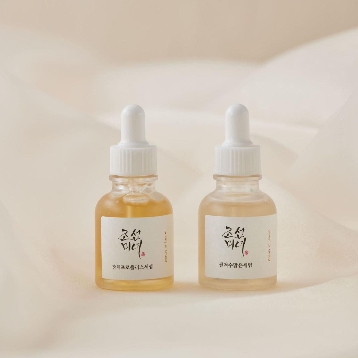 two bottles of liquid on a white cloth